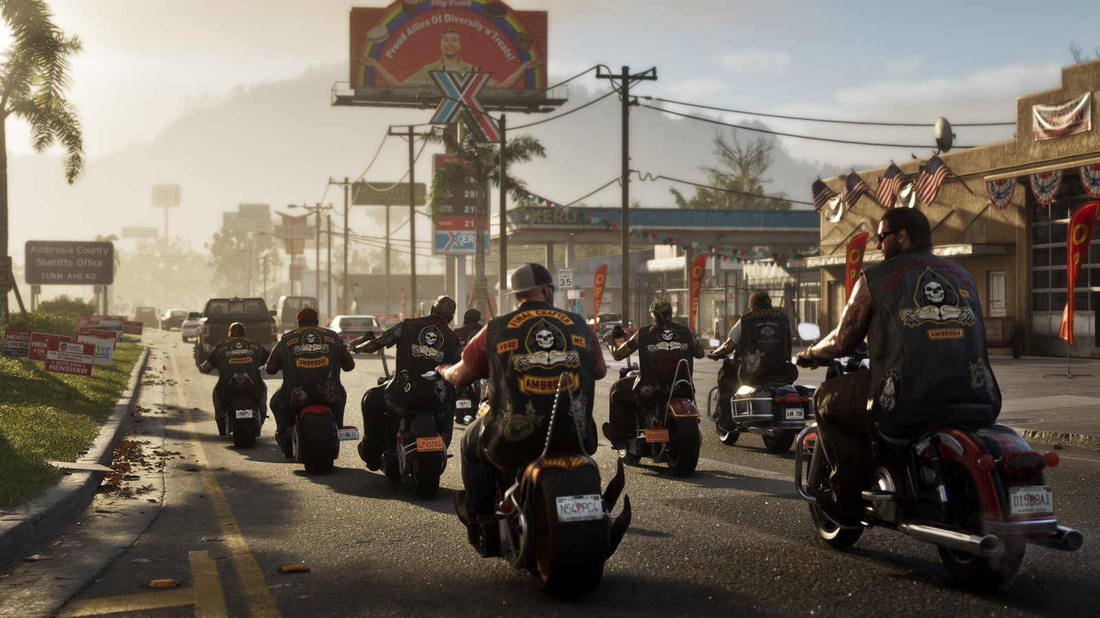 Grupo de motociclistas em Ambrosia andando por uma avenida com coletes de clube, bandeiras americanas e placas comerciais ao fundo.