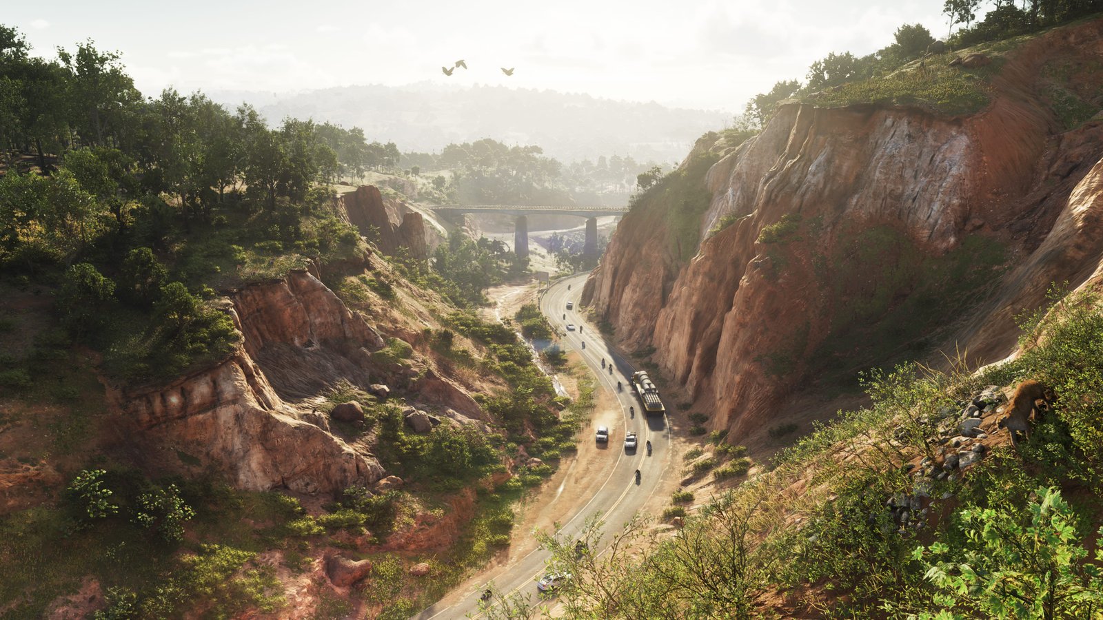 Estrada cortando cânions e vegetação no Mount Kalaga National Park, com carros e motos passando entre formações rochosas.