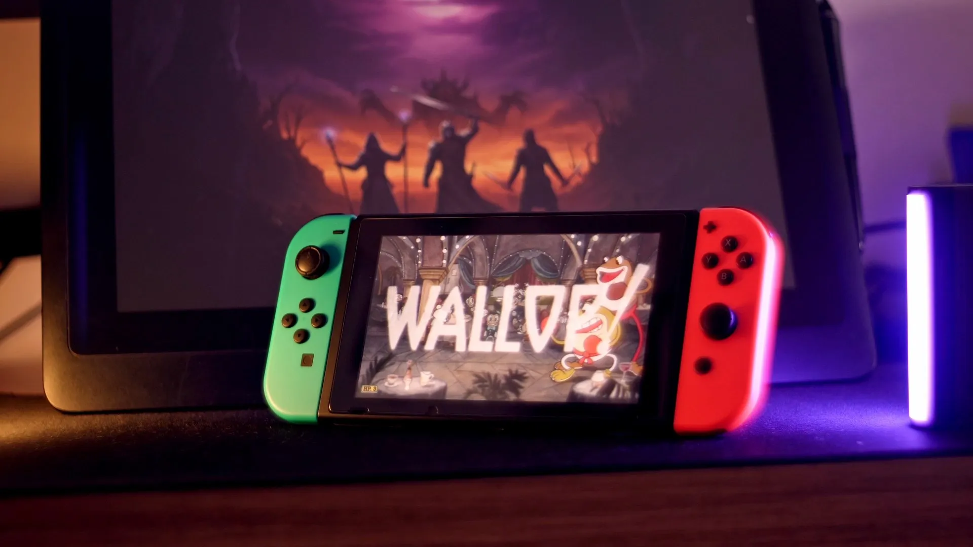 Imagem do nintendo switch 1 e um monitor no fundo com wallpaper Ranker Quest
